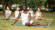 © JackF - Multinational people of different ages in park practicing yoga. Amateurs performing gymnastic. African man yoga master and followers do Janu Shirshasana. People practice sports during in nature