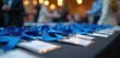 © Vadym - Many blue lanyards, name tags arranged on table. Event preparation underway. Indoor setting. Potential for business meeting. Rows of lanyards. Ready for attendees. Professional event meeting. Neatly