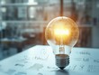 © jannoon028 - Glowing Light Bulb Over Development Sketch Symbolizing Ideas and Innovative Solutions Process on Table