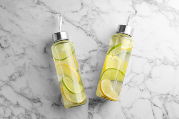 Wall Mural - Lemon water with lime in bottles on white marble table, top view