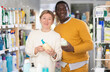 © JackF - Couple adult man and woman buyers chooses liquid hand soap in household chemicals store