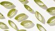 © qois - Flat lay of fresh aloe vera slices arranged on white background, showing natural gel and shadows.