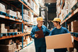 © Davor - Warehouse workers in hard hats discussing logistics while handling packages