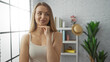 © Krakenimages.com - Woman smiling indoors looking thoughtful in a bright living room with modern decor bookshelves and plants window light enhancing her casual beauty in a serene setting