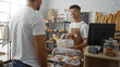 © Krakenimages.com - Two men interacting at a bakery counter with one acting as a customer and the other as a baker in a cozy indoor shop setting