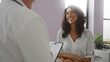 © Krakenimages.com - Woman smiling during consultation with man in medical clinic, indicating a positive interaction in healthcare setting indoors.
