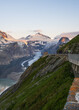 © Alexander - Road leads to majestic Grossglockner mountain, Pasterze Glacier. Snowy peaks on horizon. For theme of travel, nature, outdoor activities.