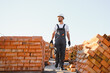© Serhii - construction mason worker bricklayer installing red brick with trowel putty knife outdoors