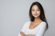 © kazakova0684 - A studio portrait of a young Asian woman expressing confidence, her arms crossed and a bold look
