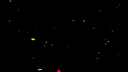 closeup explosion of shiny colorful confetti isolated on black background, texture overlay decoratio