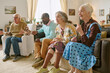 © AnnaStills - Excited biracial residents of nursing home spending time together in living room and enjoying film