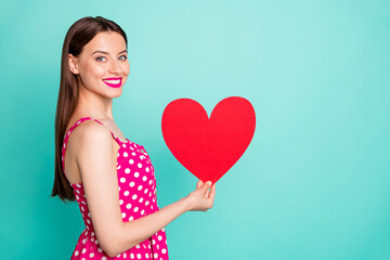 Wall Mural - Portrait of lovely youth holding paper card gift for 14-february wearing polka dot dress skirt isolated over teal turquoise green background