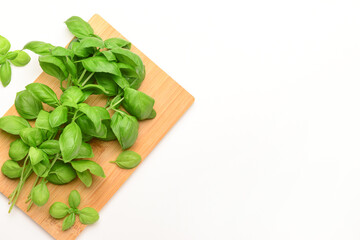 Canvas Print - Wooden board with fresh green basil on white background