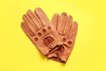 Wall Mural - Pair of leather male gloves on yellow background