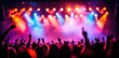 © Grigorio - Crowd cheering at the concert, with colorful smoke in front of stage lights.