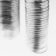© Mint Images - Abstract of metal coiled slinky, length of fine wire wound around and stretched, black and white image.