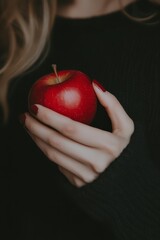 Sticker - Close up of a hand holding a red apple, woman's hand and fingernails detailed, dark background, dramatic lighting style, soft focus on the apple and