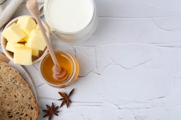 Wall Mural - Sweet honey, butter, bread and milk on white table, flat lay. Space for text