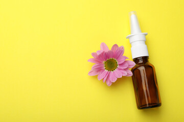 Wall Mural - Allergy treatment. Nasal spray and flower on yellow background, top view. Space for text