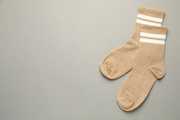 Wall Mural - Pair of soft socks on light grey background, top view. Space for text