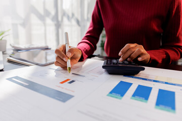 Wall Mural - Business financing accounting banking concept. Business woman hand doing finances and calculate on desk about cost at home office. Woman working on desk with using calculator, finance accounting.
