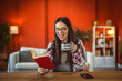 © Miljan Živković - one young adult woman read a book and drink coffee at home