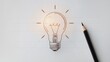 © Tom - A creative sketch of a light bulb with a glowing effect, placed beside a sharpened pencil on a white paper background, symbolizing inspiration and ideas.