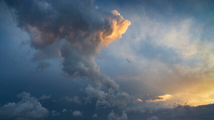 Wall Mural - dramatic sunset sky with yellow, blue and orange thunderstorm clouds.
