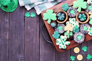Aufkleber - St Patricks Day shamrock dessert board. Green cookies and sweets. Top down view table scene over a rustic wood background with copy space.