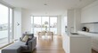 © Hello Stock - A sleek open plan living and kitchen area with a cozy gray sofa and a dining table in the background