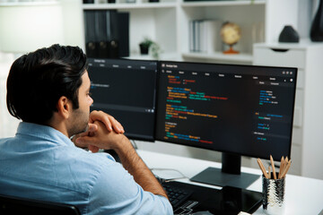 Concentrating in smart IT developer working software development coding on two pc screen, creating virus firmware application program for latest update version on website at modern office. Surmise.