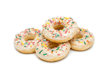 Wall Mural - A stack of frosted donuts, topped with colorful sprinkles, sits invitingly on a plain white surface.