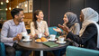 © Waqas - A diverse group of coworkers enjoying coffee while discussing their favorite cultural traditions