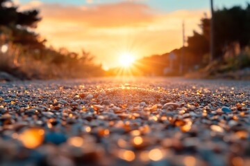 Wall Mural - Golden sunset illuminates a gravel road adorned with glistening pebbles in a tranquil landscape