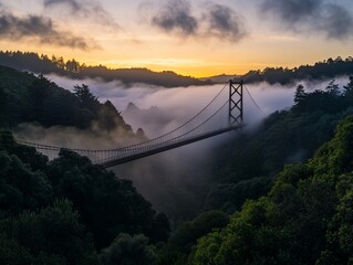 Wall Mural - Suspension bridge shrouded in fog at sunrise, nestled in a valley between lush green hills.