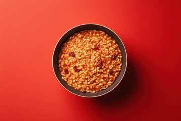 Canvas Print - Bowl of risotto with cranberries against red background