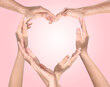 © New Africa - People making heart shape with hands on pink background. Teamwork, unity, togetherness