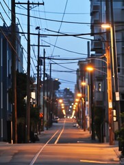 Aufkleber - Urban street at dusk with power lines and glowing street lights creating a quiet atmosphere : Generative AI
