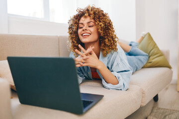 Wall Mural - Smiling Woman Typing on Laptop at Home, Enjoying Freelance Business in Cozy Living Room