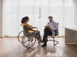 © Singh - Health care latin woman sick sit wheelchair with man doctor caucasian two people check and treat patients talk help support explain medicine sick person in take care your health hospital clinic