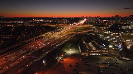 Wall Mural - Highway traffic at sunset, aerial view of 401 and 404 in Ontario, warm orange sky
