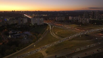 Wall Mural - Busy ontario highways at sunset, urban buildings and warm light, aerial view