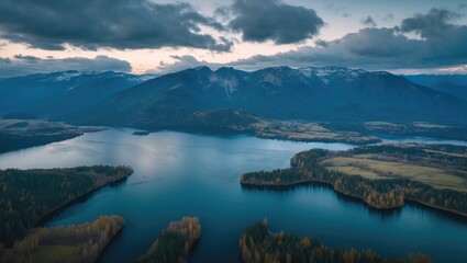 Poster - Aerial View of Serene Lake Surrounded by Majestic Mountains Under Cloudy Evening Sky in Tranquil Natural Landscape