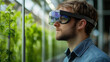 © ganlaya - A young engineer wearing AR glasses, designing a smart sustainable building with an interactive 3D hologram showcasing solar panels, wind turbines, and water recycling systems.