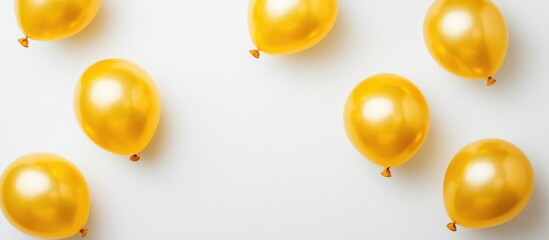 Elegant gold party balloons scattered on white background with ample empty space for text and festive design accents