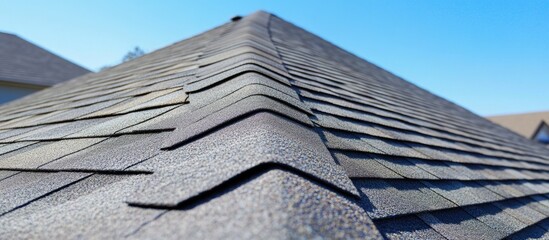 Wall Mural - Roof tiles on a sloped roof showcasing overlapping design and texture against a clear blue sky background