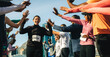 © Jacob Lund - Happy female runner celebrates as crowd cheers during outdoor marathon