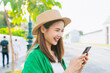 © sitthiphong - Cheerful beautiful Asian woman holding smartphone and camera with looking for tourist attractions.