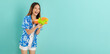 © sitthiphong - Songkran festival in Thailand, Happy smiling young Asian woman in summer wearing floral shirt and holding water guns in blue background.