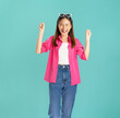 © sitthiphong - Portrait of confident Asian woman casual pink shirt raise your hands and be excited and happy, isolated on blue background.